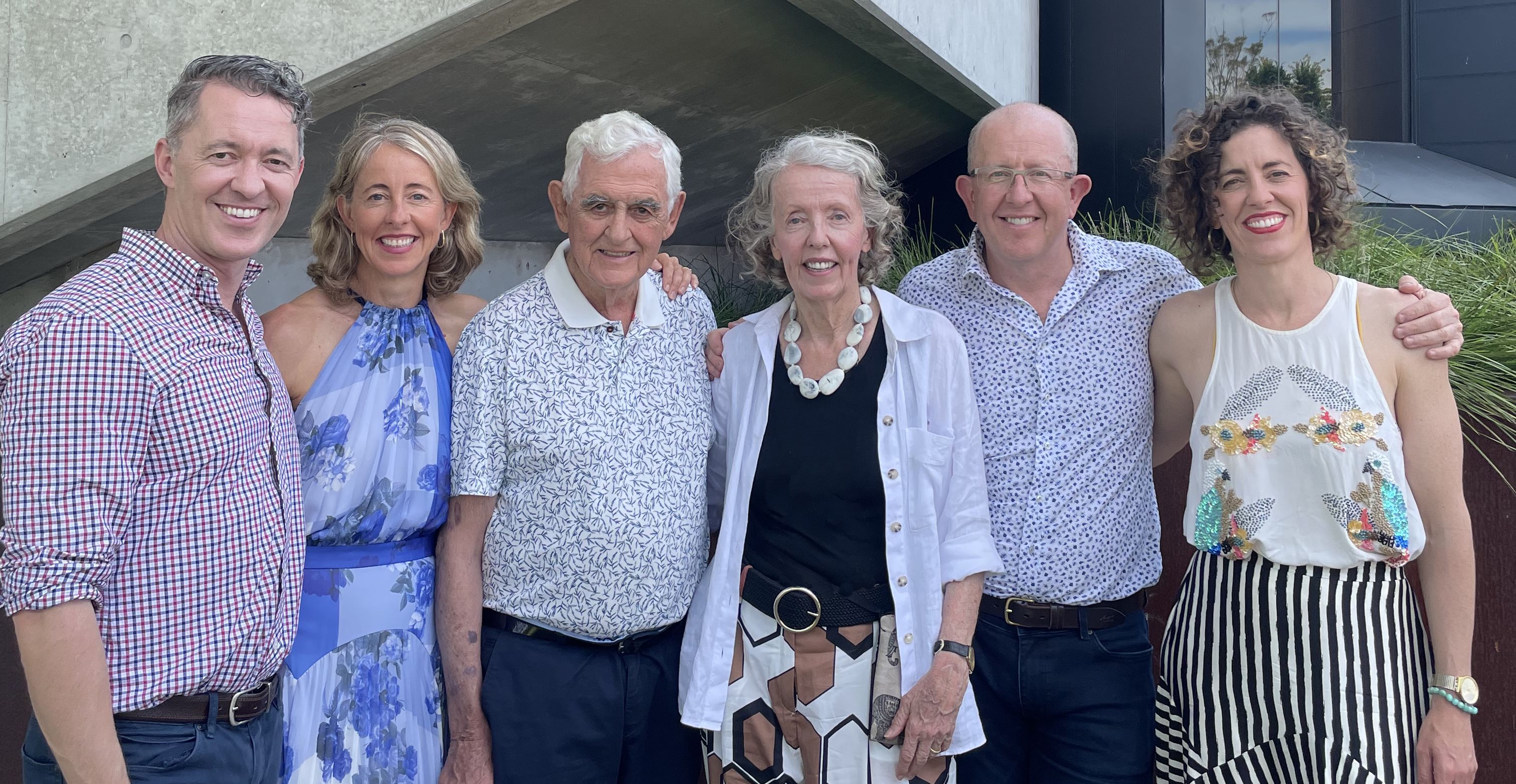 A group of three men and three women smiling for a photo.